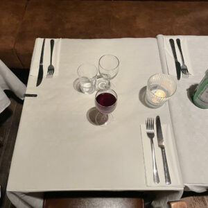 Ett dukat bord utan tallrik med fyllt vinglas
